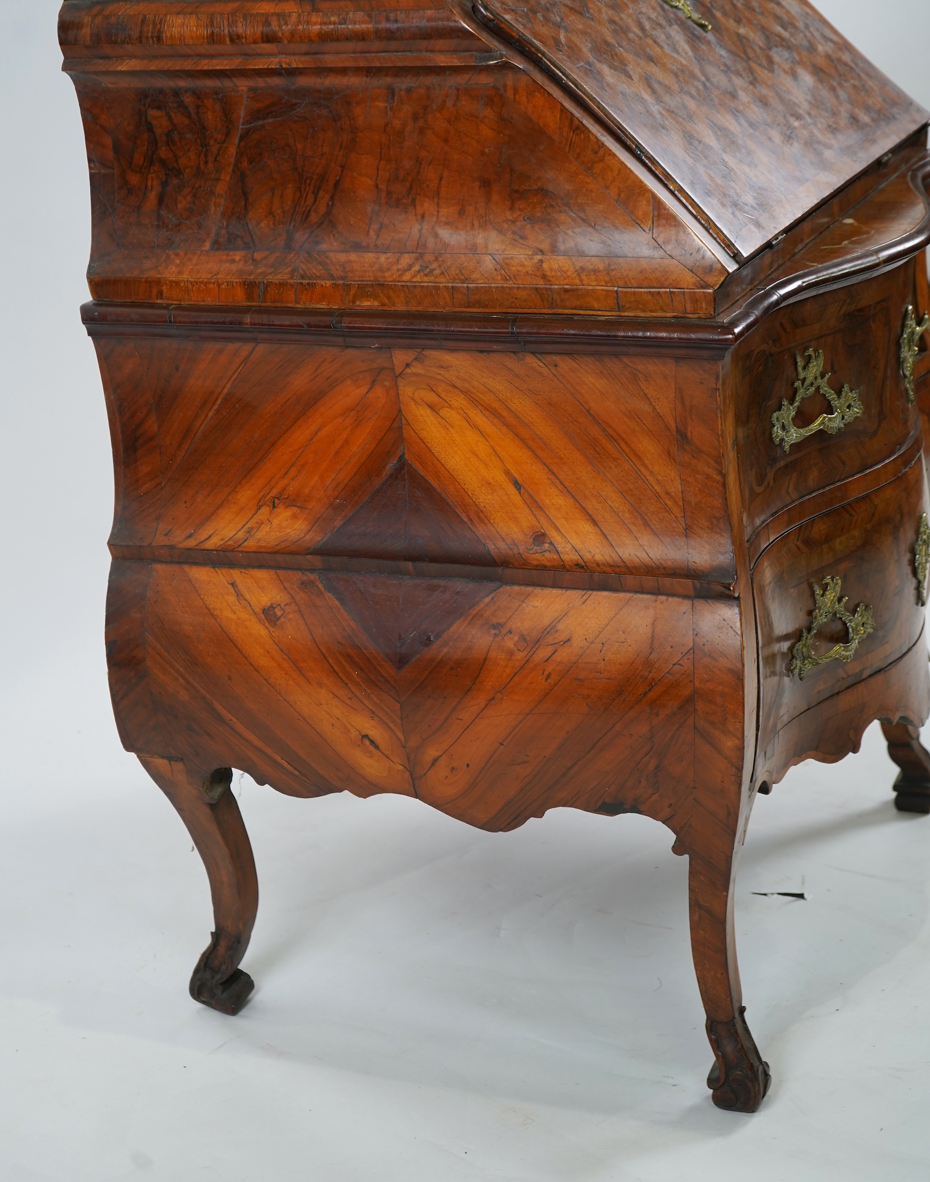A mid 18th century North Italian or Maltese walnut and olive wood gilt metal mounted serpentine bureau cabinet